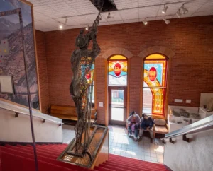 Anatomy of a Miner overlooking stained glass framing the balcony.
