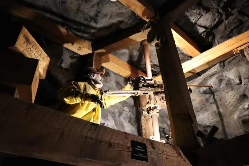 Museum exhibit of a hard rock driller in square set timber stope