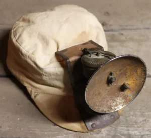Carbide lamp on a canvas cap.
